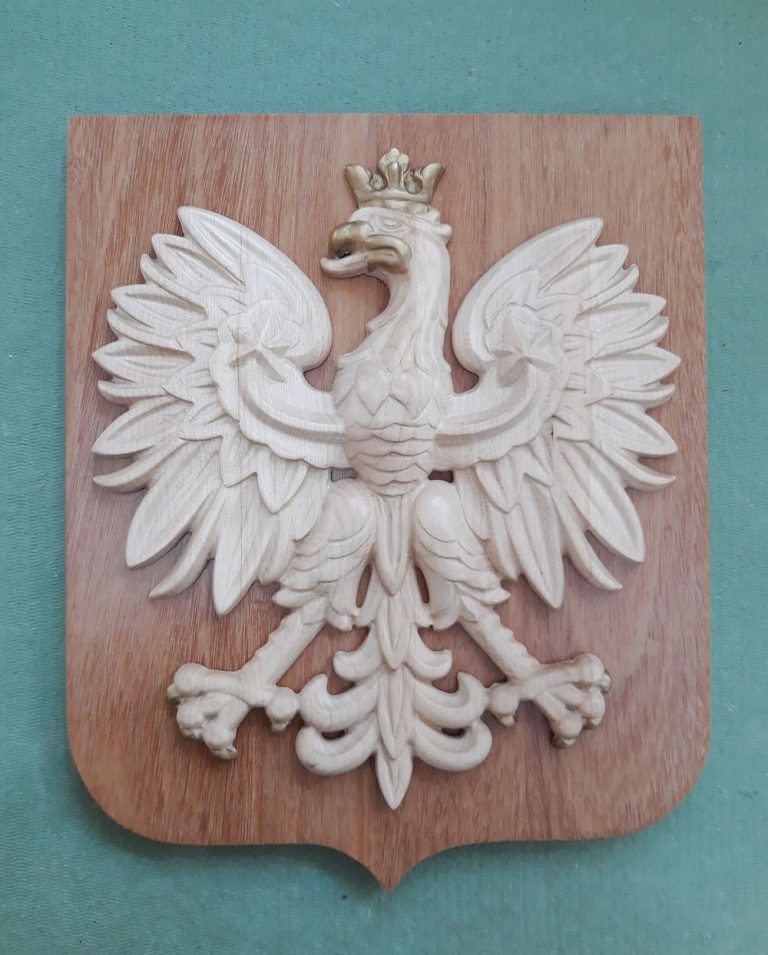 rzeźby płaskorzeźby aplikacje - Godło Polski. Wyrzeźbione z drewna - białego jawora, tło z egzotycznego Bangkirai. Dostępne w dowolnej wielkości. Na zdjęciu wielkości 34x28 cm. Cena zależy od wielkości godła i gatunku zastosowanego materiału. Możliwa wersja bez tarczy.